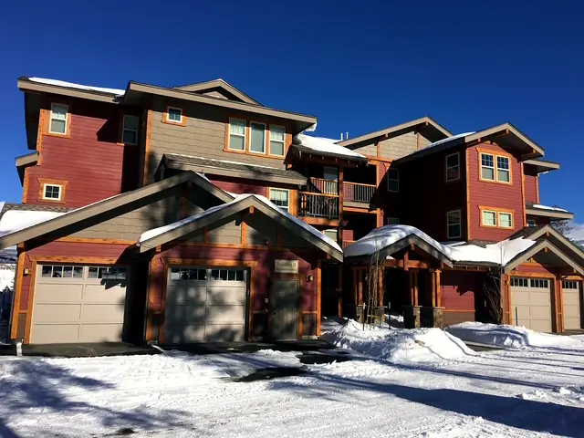Multi-family mountain condos with timber accents and cedar garage doors in winter