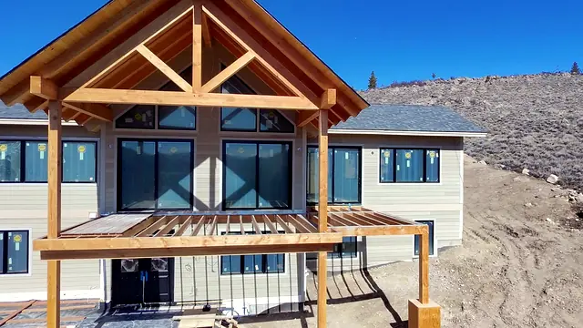 Timber-frame covered deck under construction on a luxury mountain home