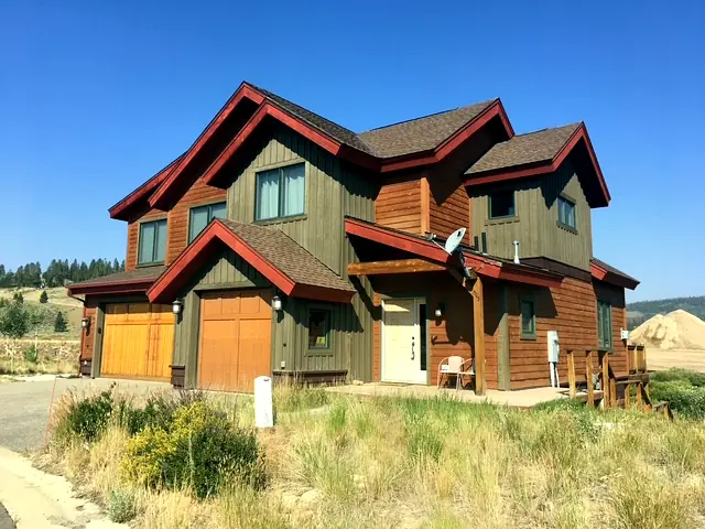 Mountain duplex with cedar garage doors and timber porch details, built by Rondeau Construction