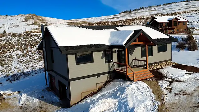 Drone aerial of a finished custom home on a snowy hillside near Granby, Colorado