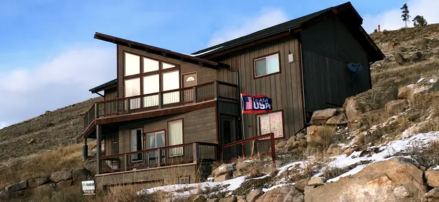 Multi-level custom mountain home with wraparound decks on a rocky hillside, built by Rondeau Construction