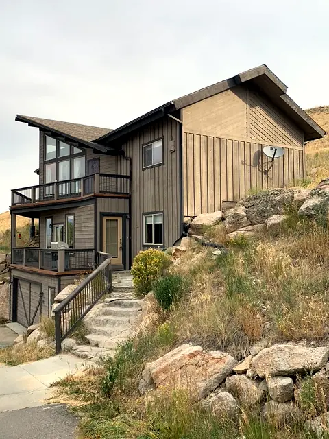 Split-level custom home built into a rocky hillside with stacked decks