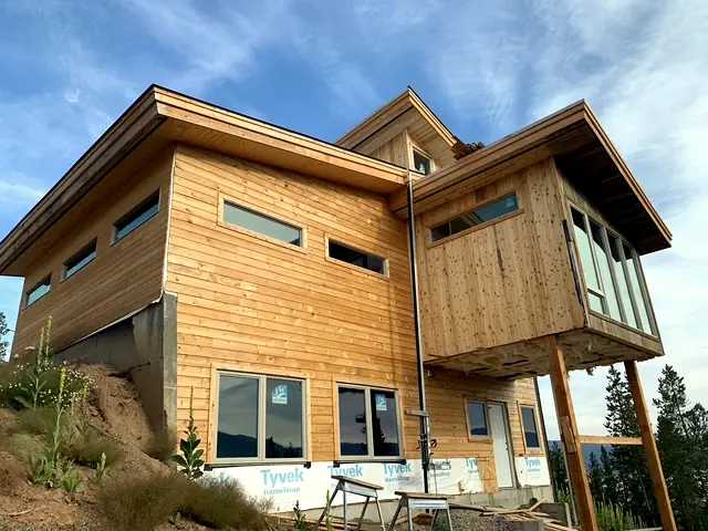 Modern cedar home under construction with cantilevered window bay